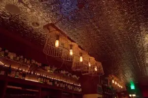 Pressed tin ceiling glows w/ artful lighting