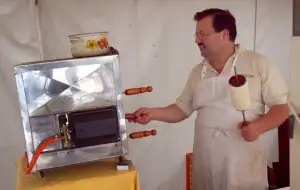 Baumkuchen (a flaky pastry shaped like the ring of a tree, crusted in cinnamon & sugar) being baked to order at Grünmarkt (a "farmers market" or food market daily in Universitätsplatz square)