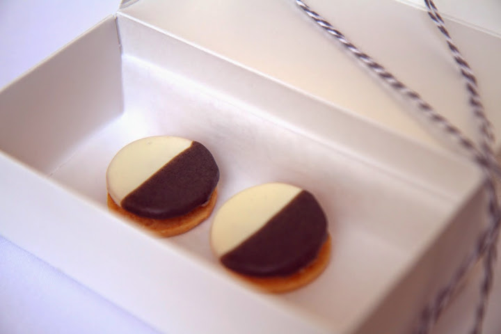 The first bite: soft, savory black & white cheese-apple cookies arrive in a box tied by striped string; the meal ends with a similar box & identical cookies but sweet with cinnamon