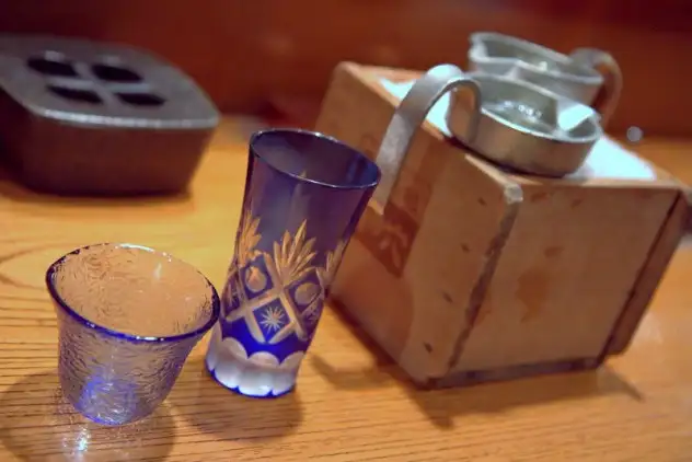 Beautiful sake glasses and pitchers chilling on ice in a box at Sake No Ana